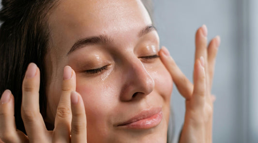 Woman applying facial oil to her skin as part of an oil-based skincare routine